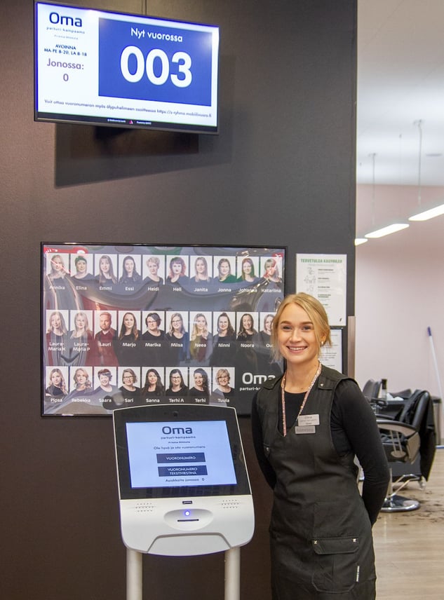 Cosmetologist standing next to Qmatic Intro 17