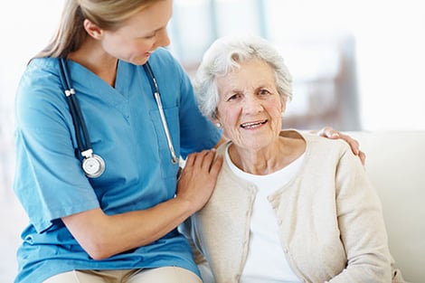 kvinnlig sjuksköterska håller om äldre kvinnlig patient