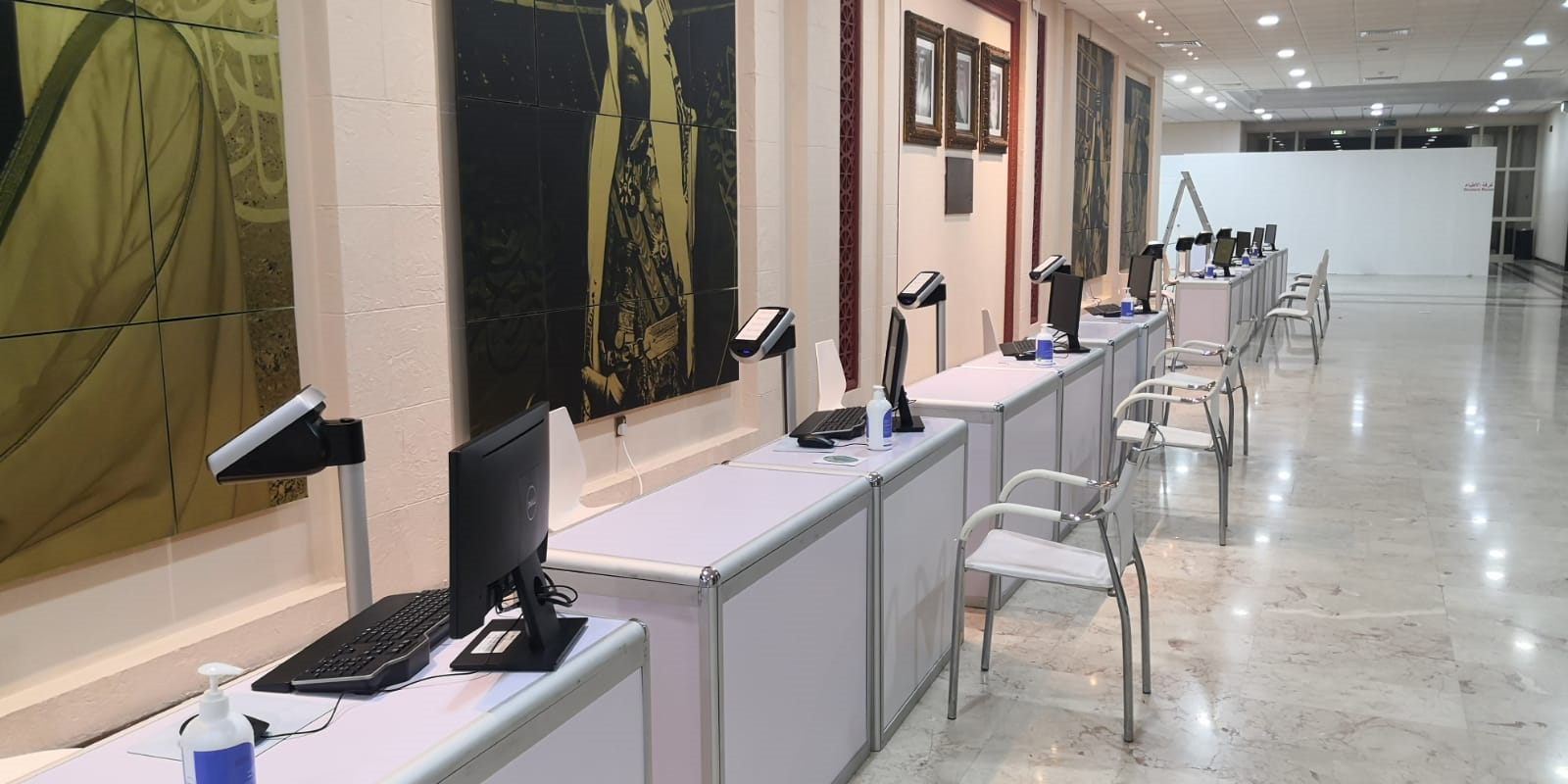 row of desks in a room with kiosks 